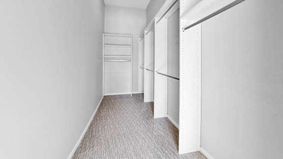 A long hallway with white walls and a carpeted floor.