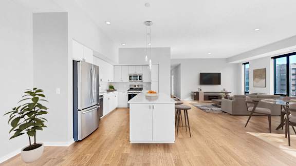 A modern kitchen with a white island and stainless steel appliances.