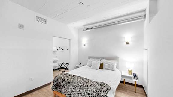 A bedroom with a bed, nightstand, and lamp.