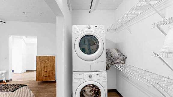 A white washing machine is in a laundry room.