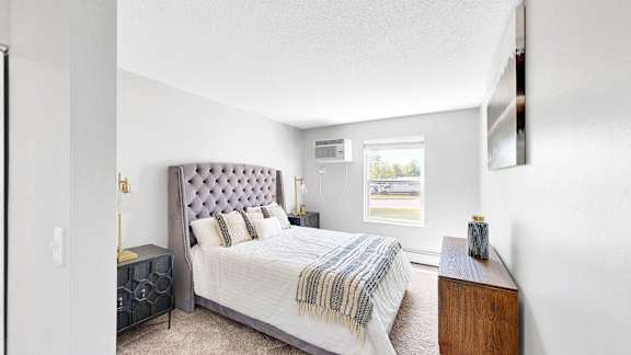 A bedroom with a large bed and a window.