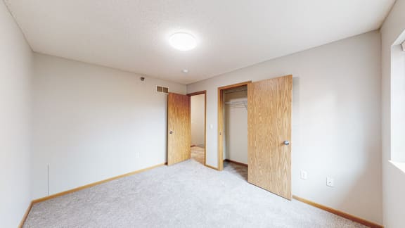 an empty room with a door to a closet