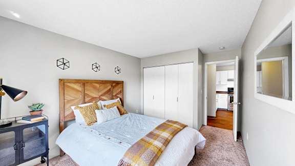 A bedroom with a bed, a nightstand, and a lamp.