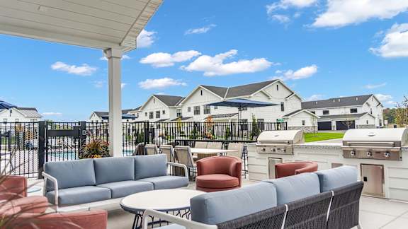 A patio with a white table and chairs is set up on a sunny day.