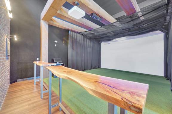 A room with a long wooden table and a white screen on the wall.