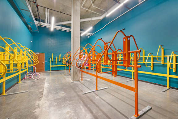 A gym with orange and blue walls and a bicycle in the corner at Soul Apartments, St. Paul, Minnesota