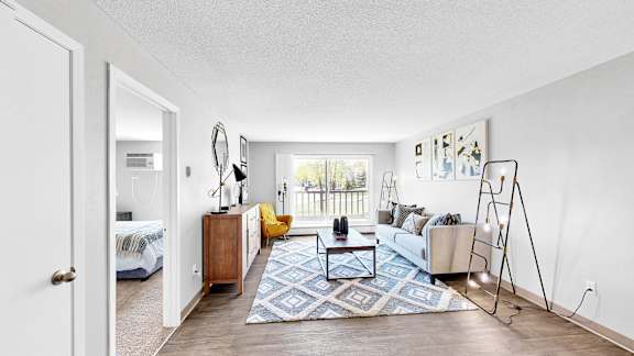 A living room with a couch, a coffee table, and a yellow chair.