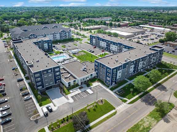 A large apartment complex with a swimming pool in the middle.
