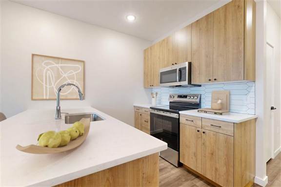 A modern kitchen with wooden cabinets and a white countertop.