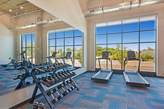 A gym with treadmills and a row of stationary bikes at Soul Apartments, St. Paul