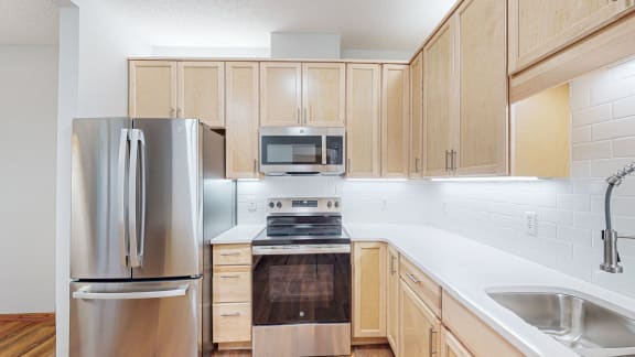 a kitchen with stainless steel appliances and wooden cabinets