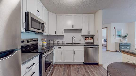A kitchen with white cabinets and stainless steel appliances.