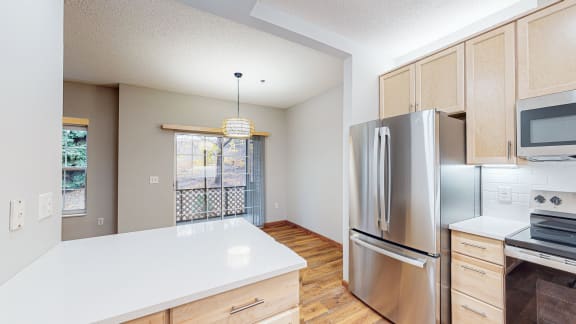 an empty kitchen with stainless steel appliances and white counter tops