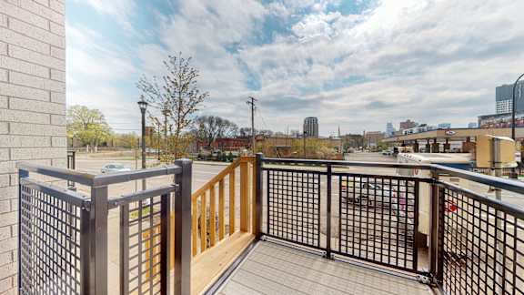 A balcony with a metal railing and wooden slats.