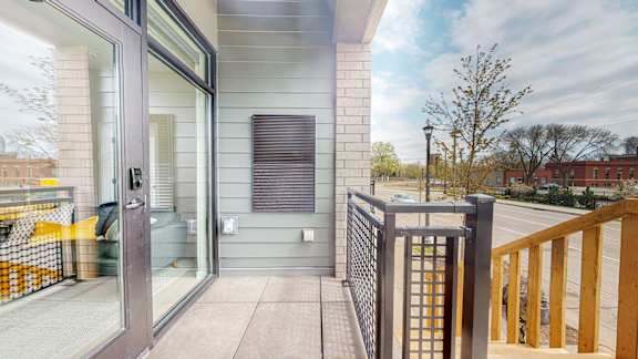 A balcony with a glass door and a metal railing.