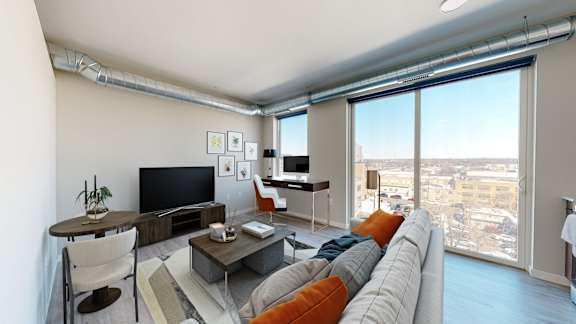 A living room with a grey couch and a television.