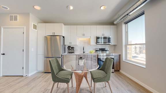 A modern kitchen with a dining table and chairs.