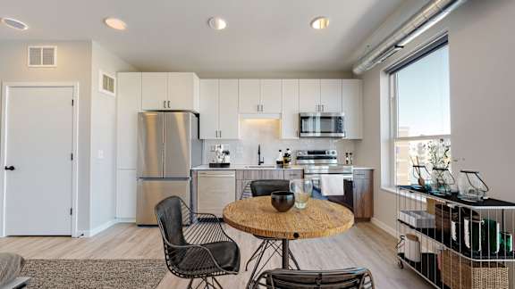 A modern kitchen with a table and chairs in the middle of the room.