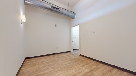 an empty room with white walls and a wooden floor