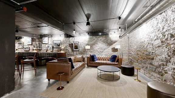 A modern living room with a stone wall and a variety of furniture.