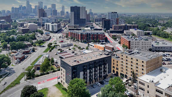 A cityscape with a mix of modern and older buildings, with a clear sky above.