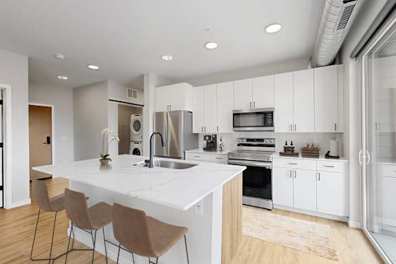 A modern kitchen with white cabinets and a large island.