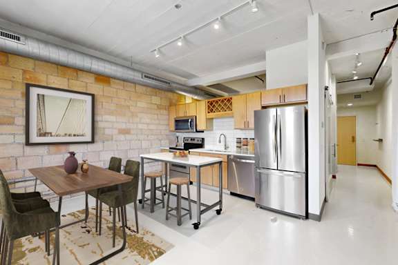 A kitchen with a table and chairs in front of a brick wall.