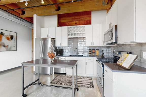 A kitchen with a refrigerator, oven, and microwave.