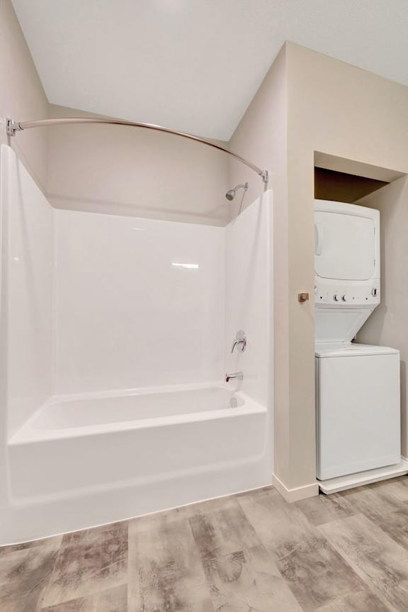 A white bathroom with a tub and a washer and dryer at Soul Apartments, Minnesota 55107