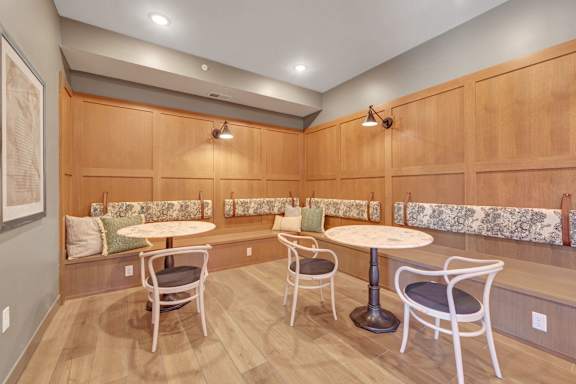 A room with wooden walls and a table with chairs.