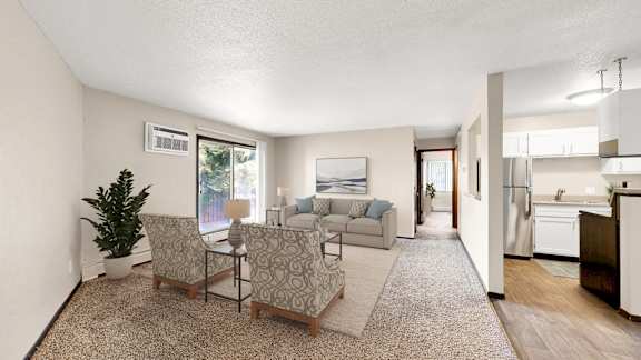 A living room with a couch, chairs, and a potted plant.