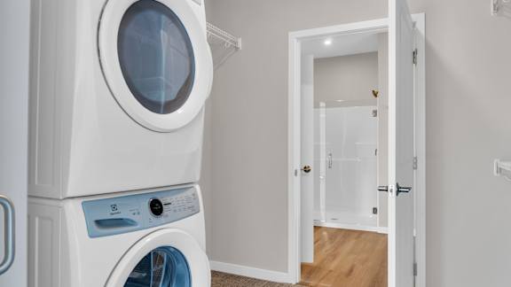 A white washing machine and dryer in a laundry room.
