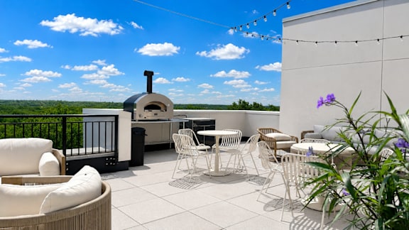 A patio with white furniture and a wood-fired oven.