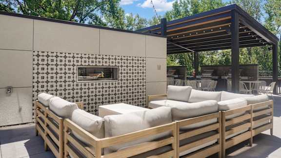 A wooden outdoor seating area with a patterned wall and a wooden pergola.