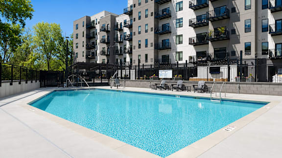 A swimming pool in front of apartment buildings.
