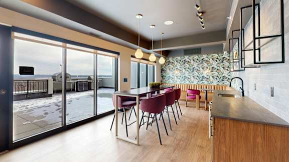 A modern kitchen with a dining table and chairs. at Ardor on the Bluffs South Loop Residences Apartments, Bloomington, Minnesota