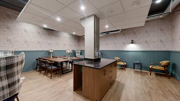 A kitchen with a wooden island and chairs at Ardor on the Bluffs South Loop Residences Apartments, Minnesota