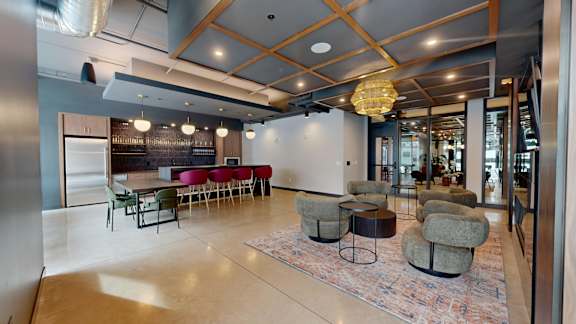 A modern room with a bar and seating area at Ardor on the Bluffs South Loop Residences Apartments, Bloomington