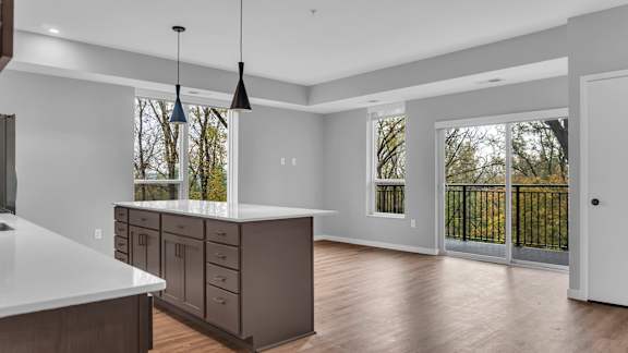 A kitchen with a white counter top and brown cabinets.