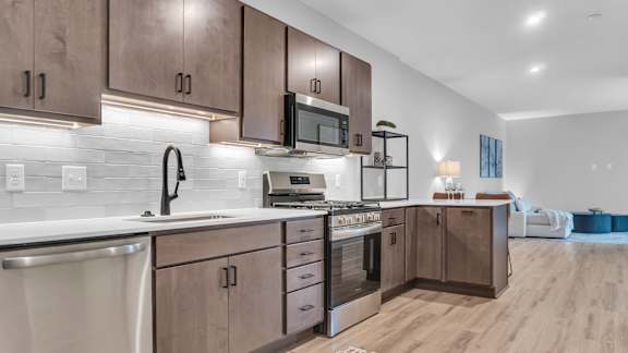 A modern kitchen with wooden cabinets and stainless steel appliances.