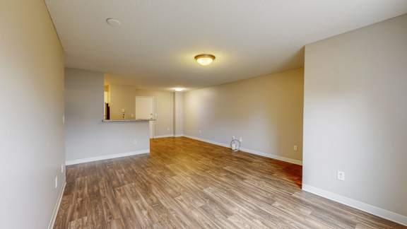 A room with wooden flooring and white walls.