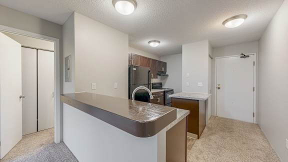 A kitchen area with a counter and a refrigerator.
