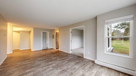 A room with a large window and wooden flooring.