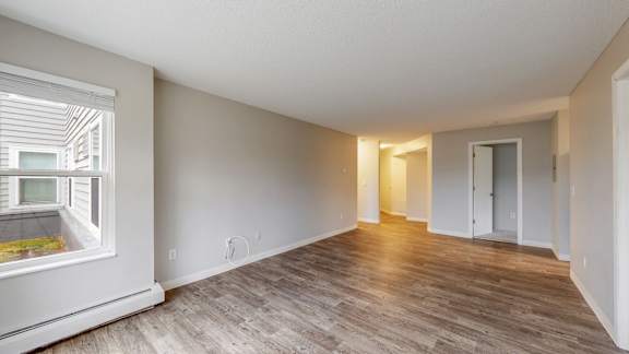 A room with wooden flooring and white walls.