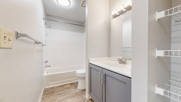A white bathroom with a toilet, sink, and bathtub.