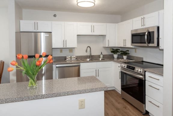 a kitchen with white cabinets and stainless steel appliances