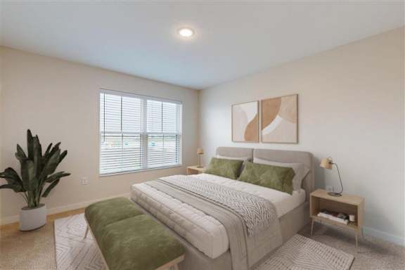 A bedroom with a large bed, a green bench, and a potted plant.