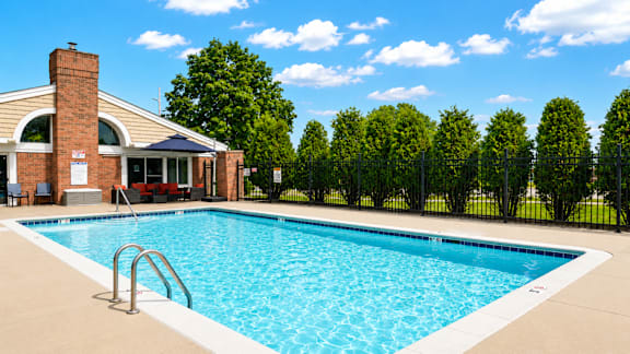 A swimming pool in a backyard with a building in the background.