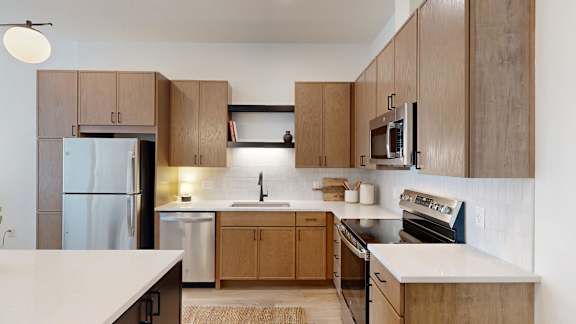 A modern kitchen with wooden cabinets and stainless steel appliances.