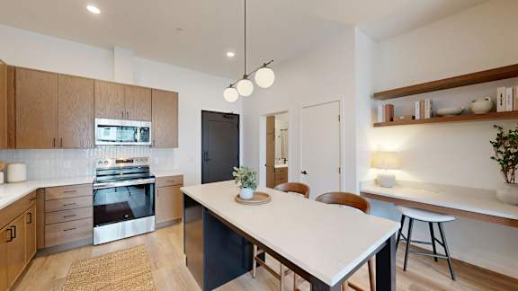 A modern kitchen with a large island and stainless steel appliances.